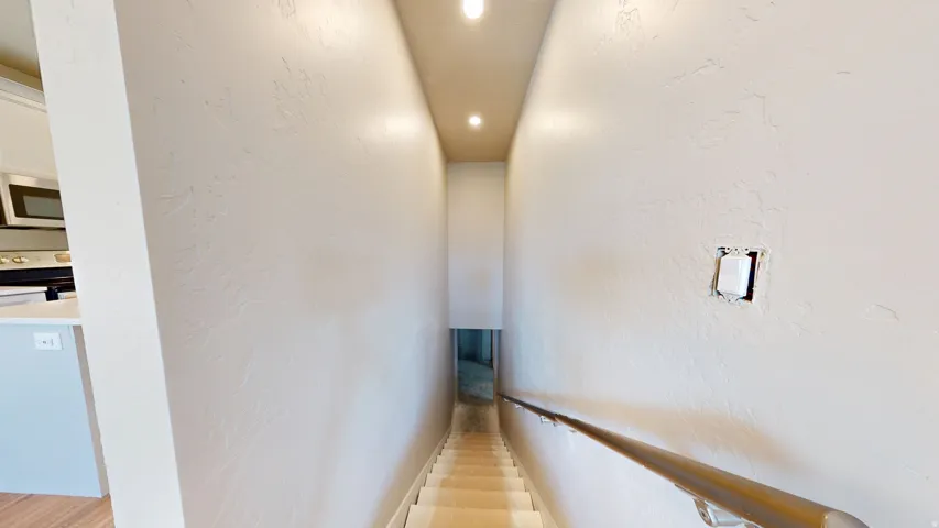 Corridor with a textured wall and recessed lighting