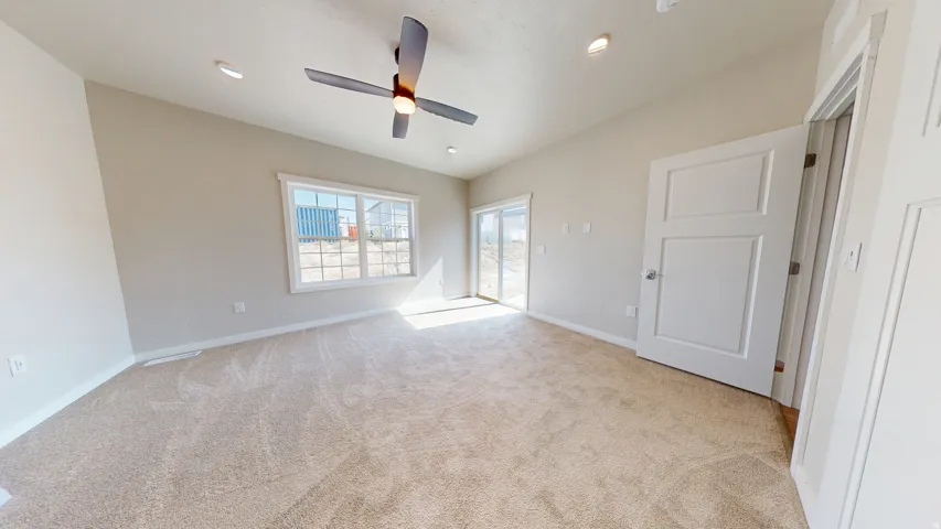 Unfurnished bedroom featuring access to outside, light colored carpet, a ceiling fan, and recessed lighting