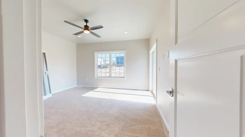Unfurnished bedroom with light carpet, ceiling fan, and recessed lighting