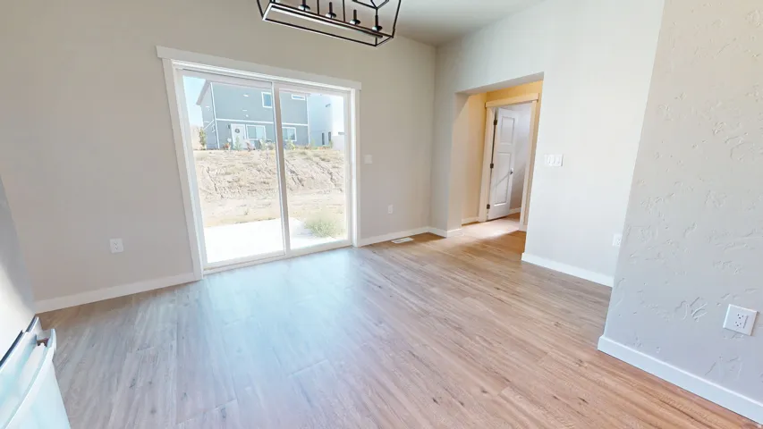 Unfurnished dining area featuring light wood-style flooring and a textured wall
