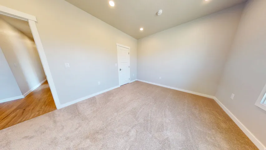 Spare room featuring light carpet, recessed lighting, and vaulted ceiling