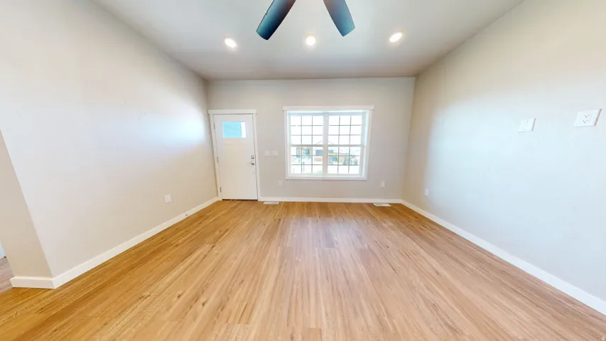 Empty room with light wood finished floors and recessed lighting