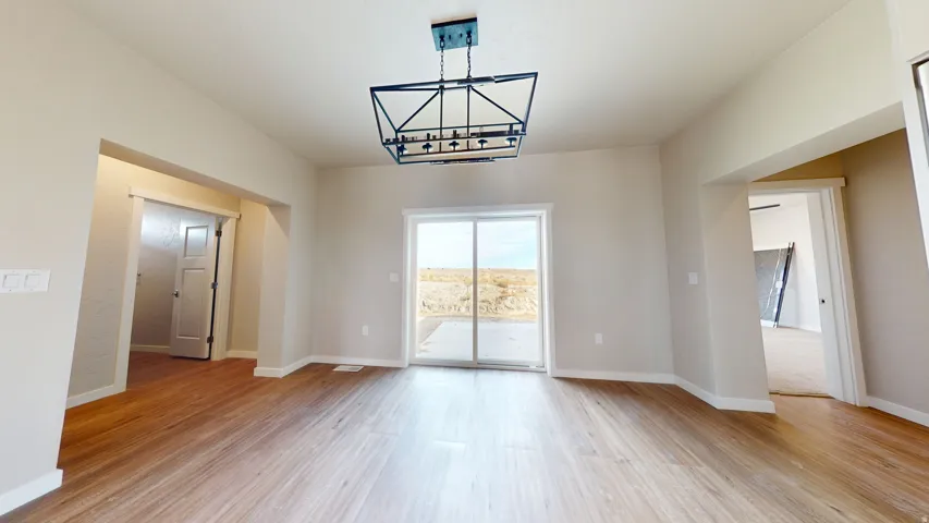 Unfurnished dining area featuring a chandelier and light wood-style flooring