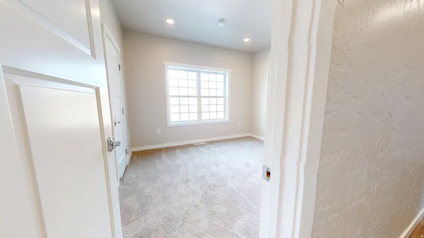 Spare room featuring light colored carpet and recessed lighting