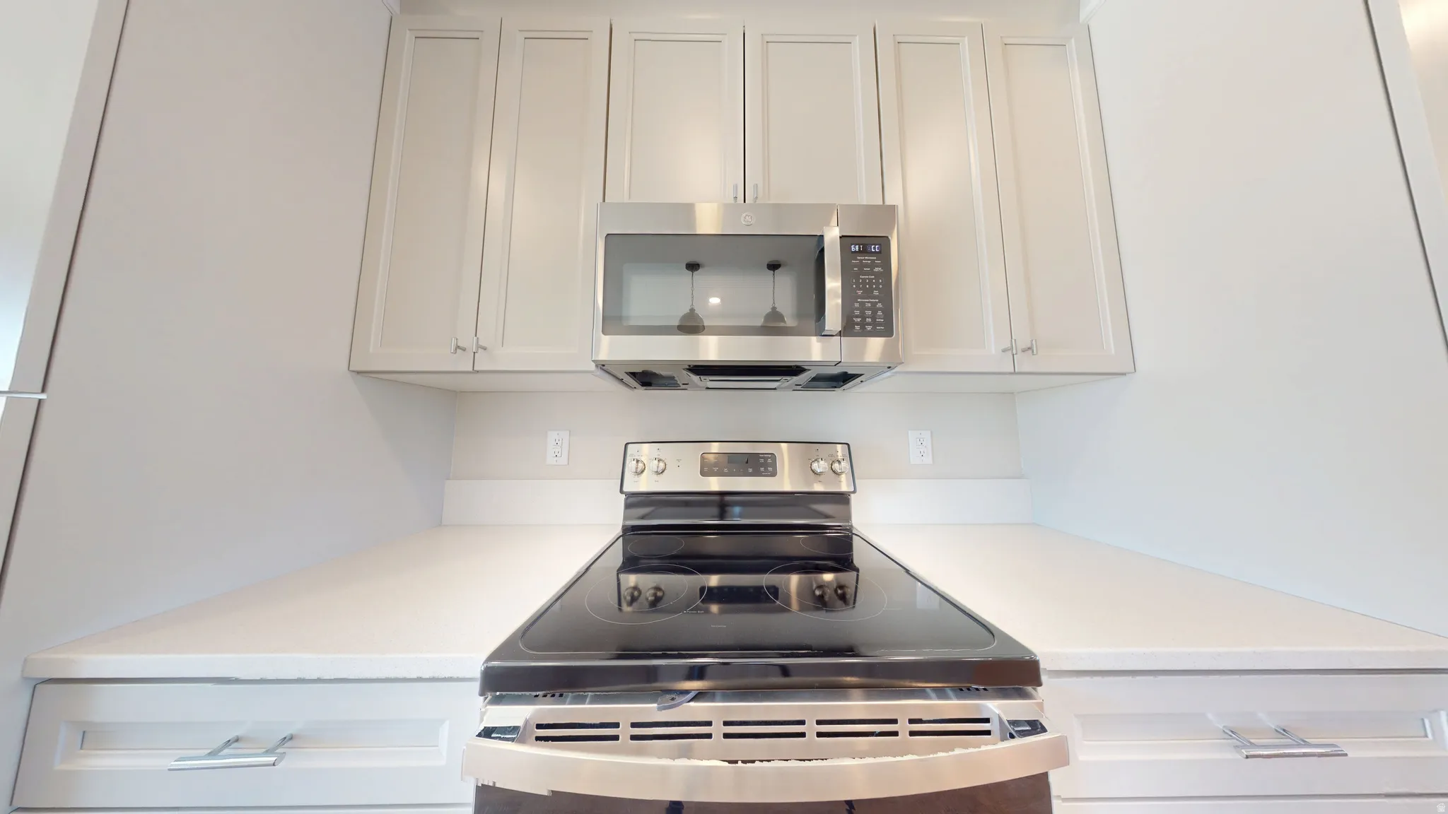 Kitchen featuring stainless steel appliances and white cabinets