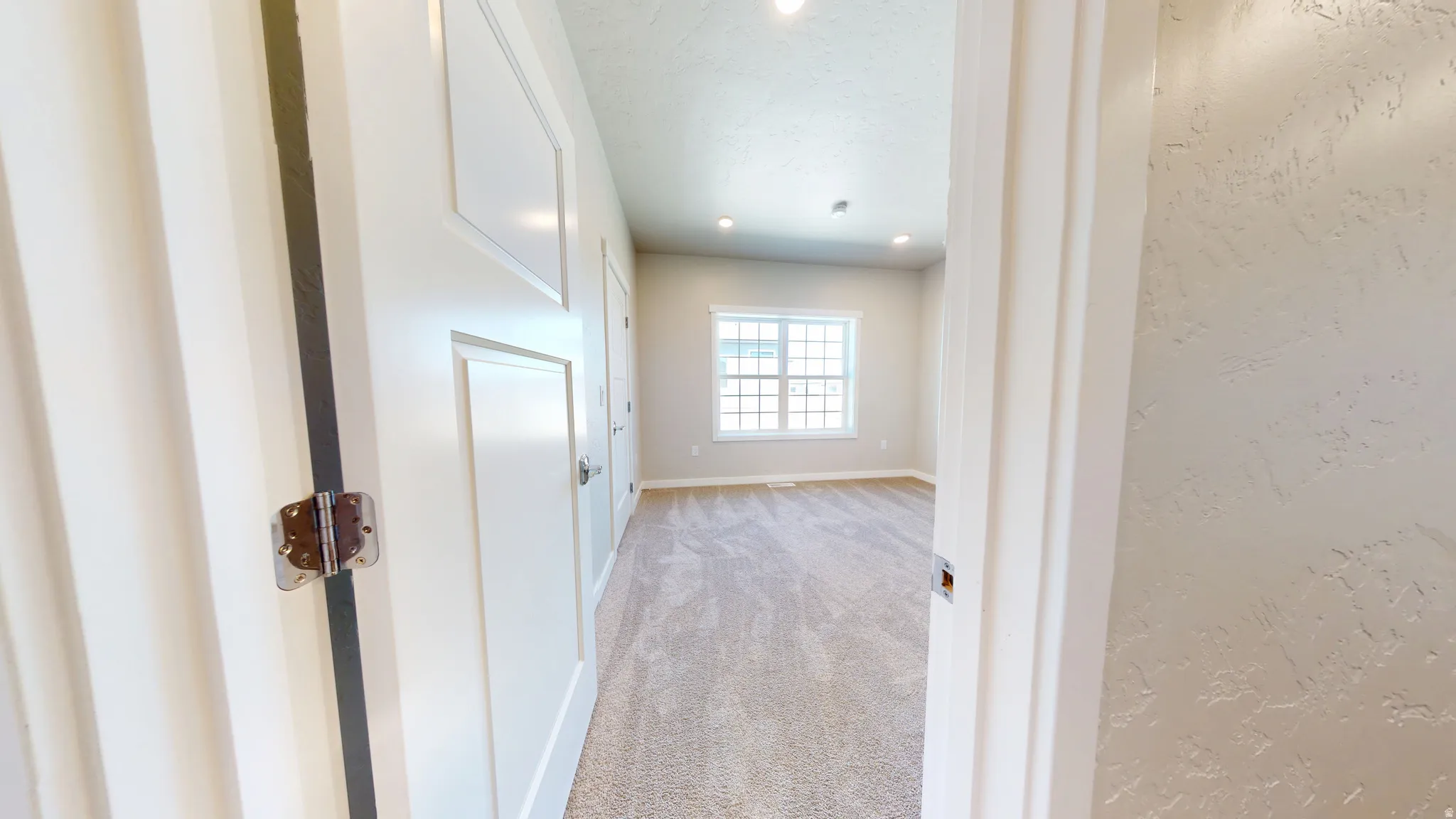 Hall featuring light carpet and recessed lighting