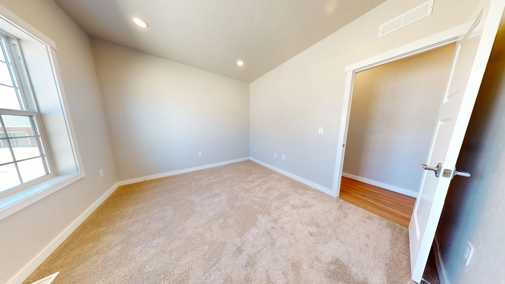Spare room with light carpet, recessed lighting, and vaulted ceiling