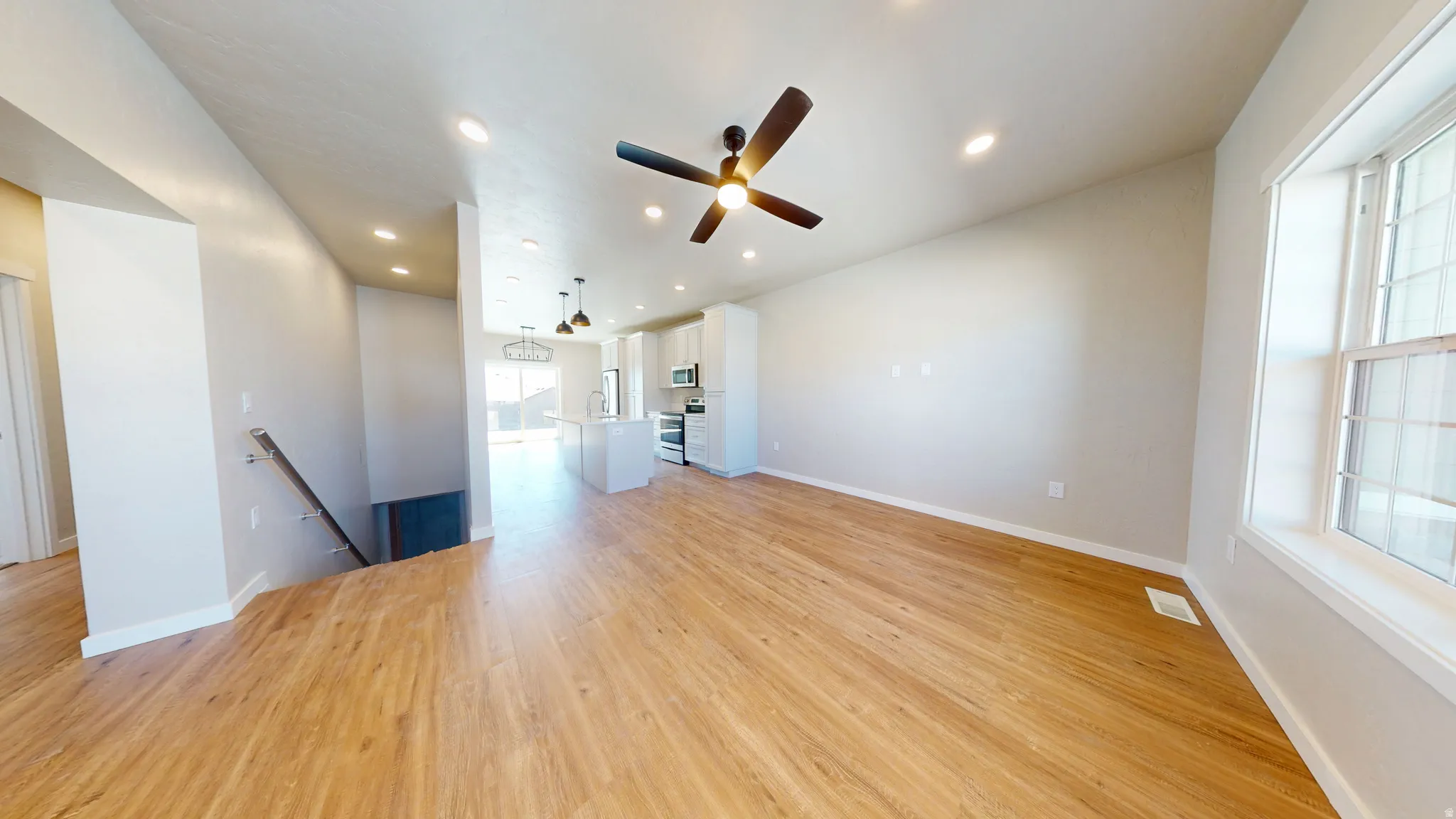 Unfurnished living room featuring light wood-style flooring, recessed lighting, and a ceiling fan