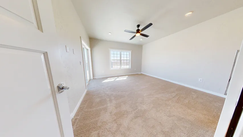 Unfurnished bedroom featuring light colored carpet, ceiling fan, and recessed lighting