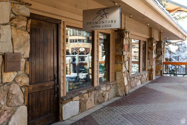Entrance to property with stone siding and a porch