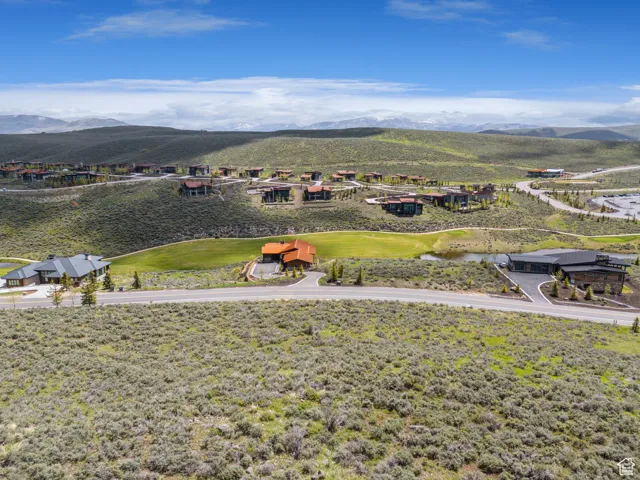 Aerial perspective of suburban area with a mountainous background and a golf club