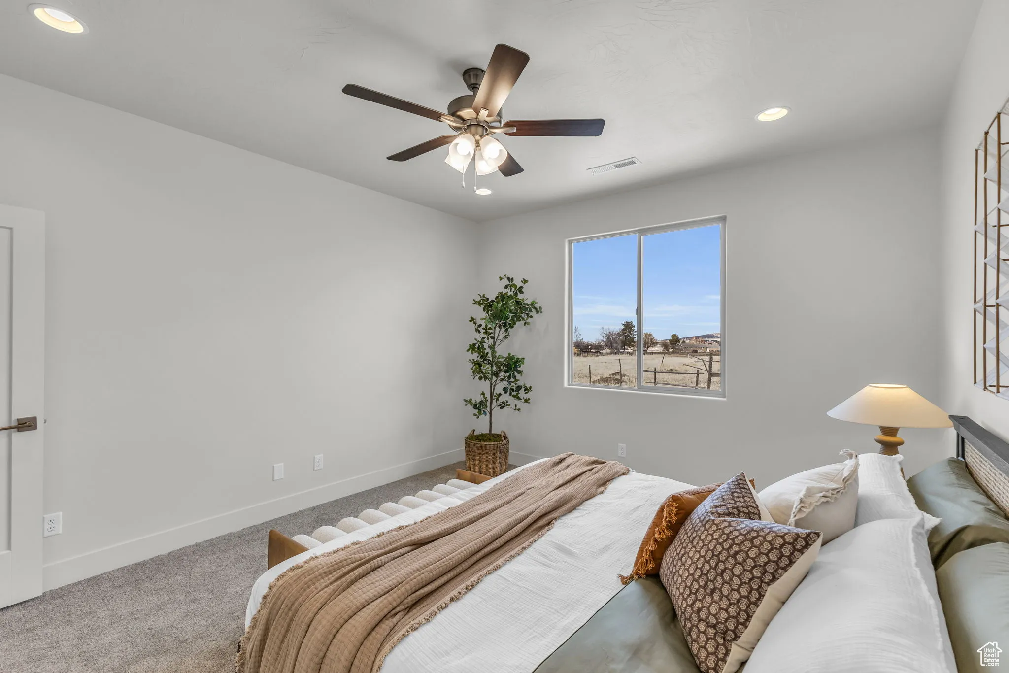 Carpeted bedroom featuring ceiling fan