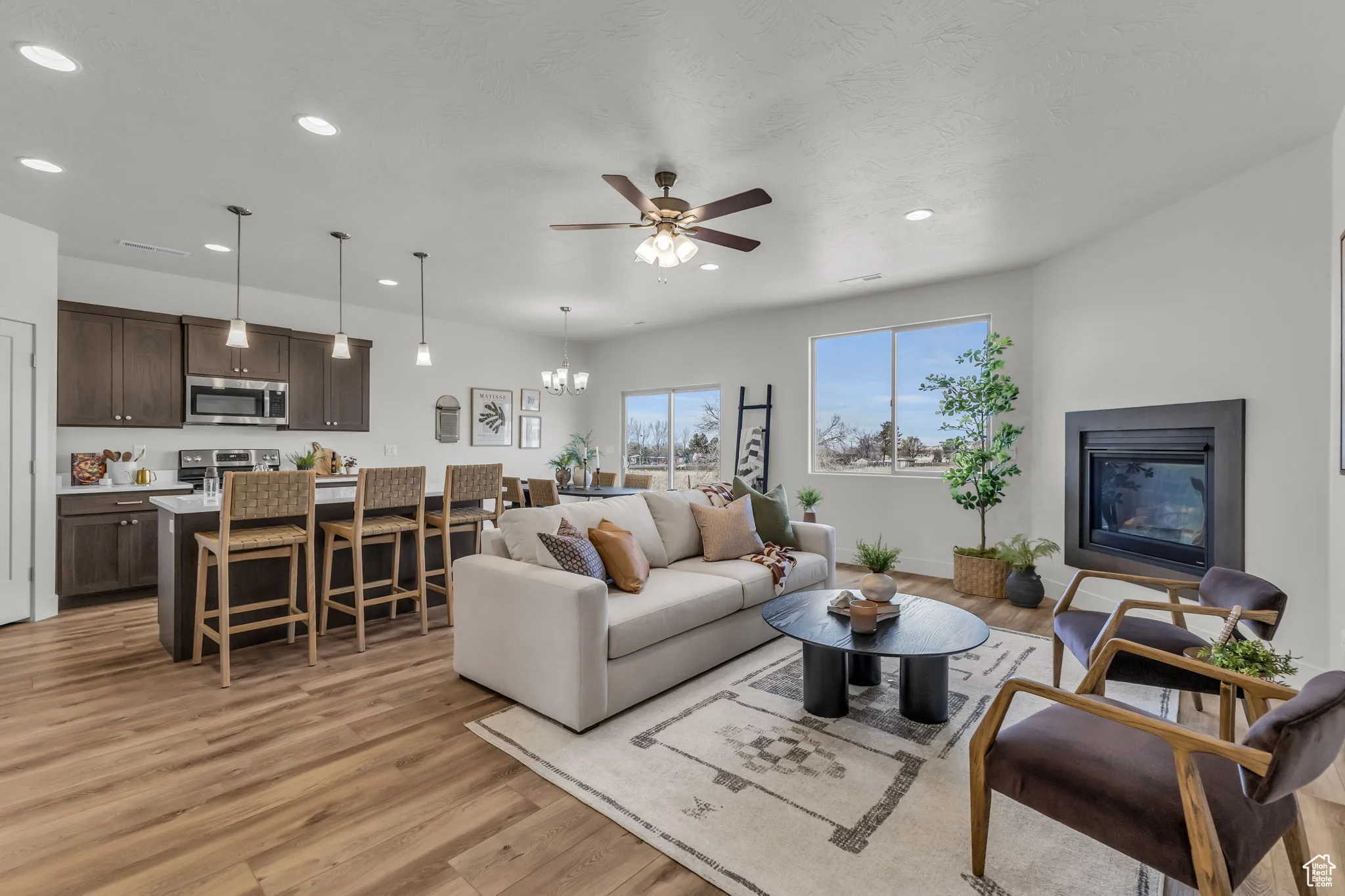 Living room featuring light hardwood / wood-style floors and ceiling fan with notable chandelier