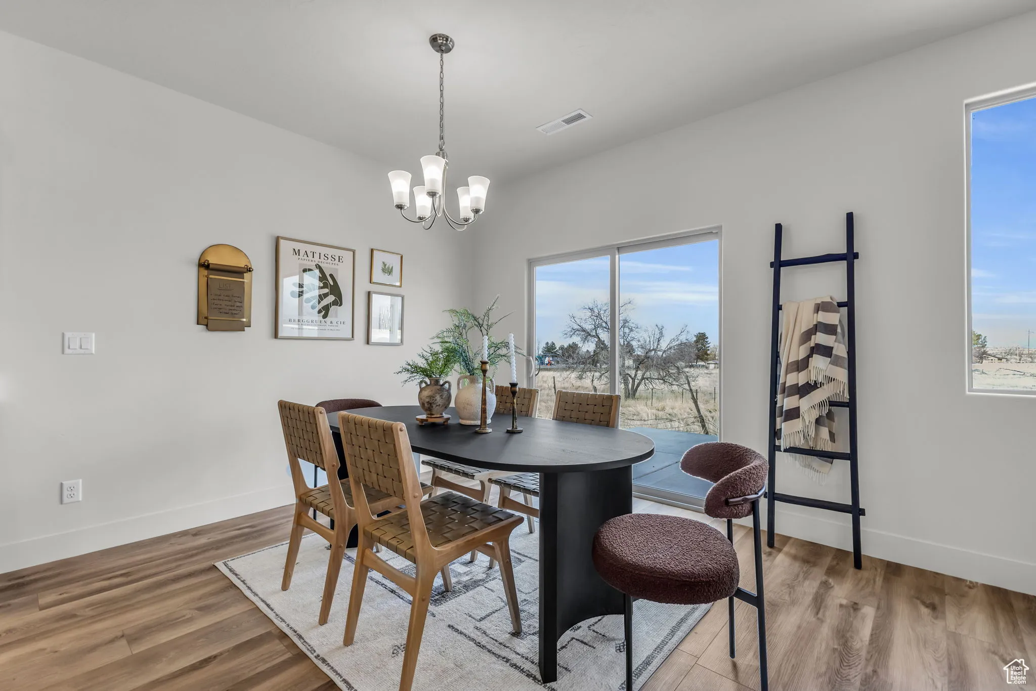 Dining space with hardwood / wood-style floors and an inviting chandelier