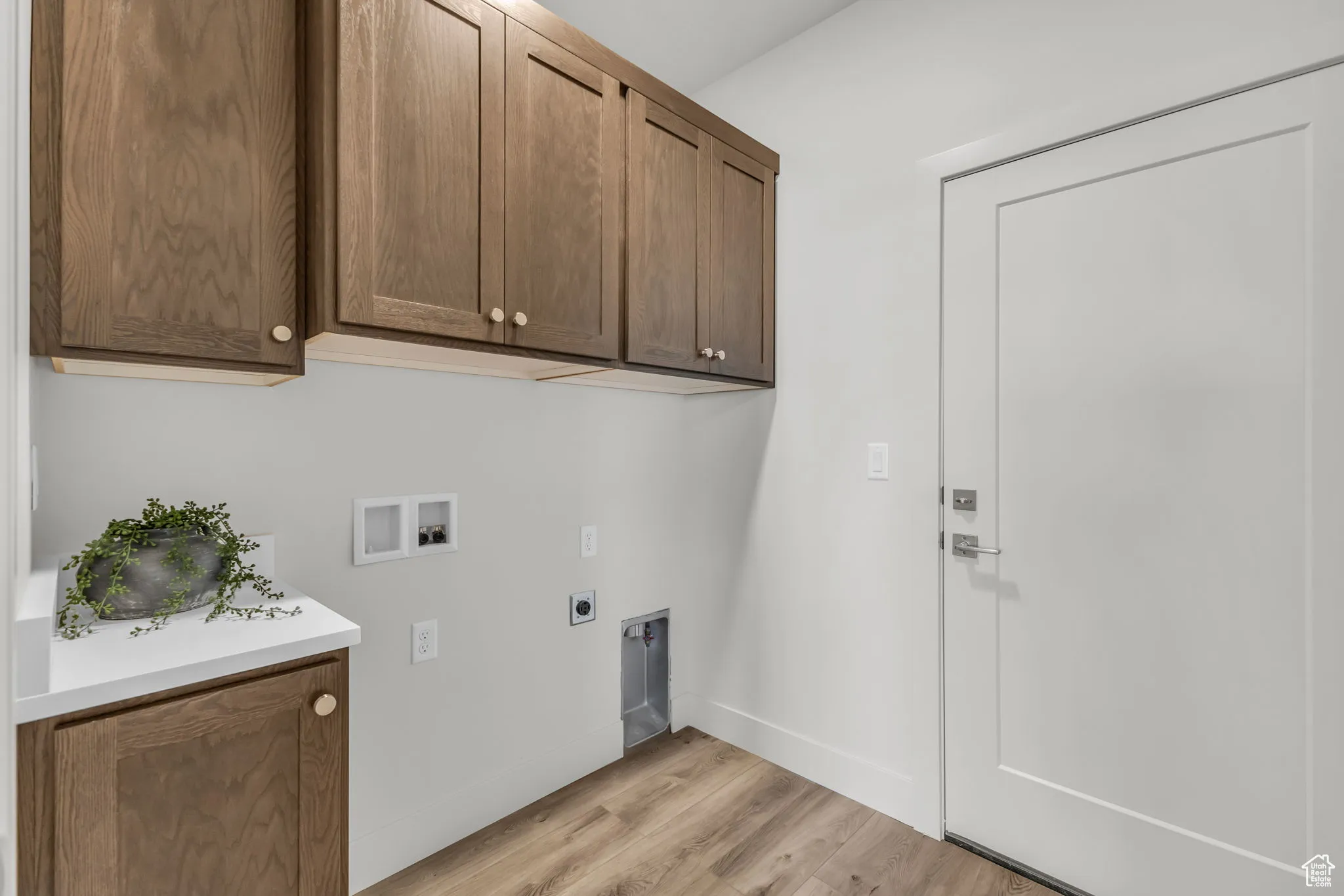 Washroom with light hardwood / wood-style floors, hookup for a washing machine, cabinets, and hookup for an electric dryer