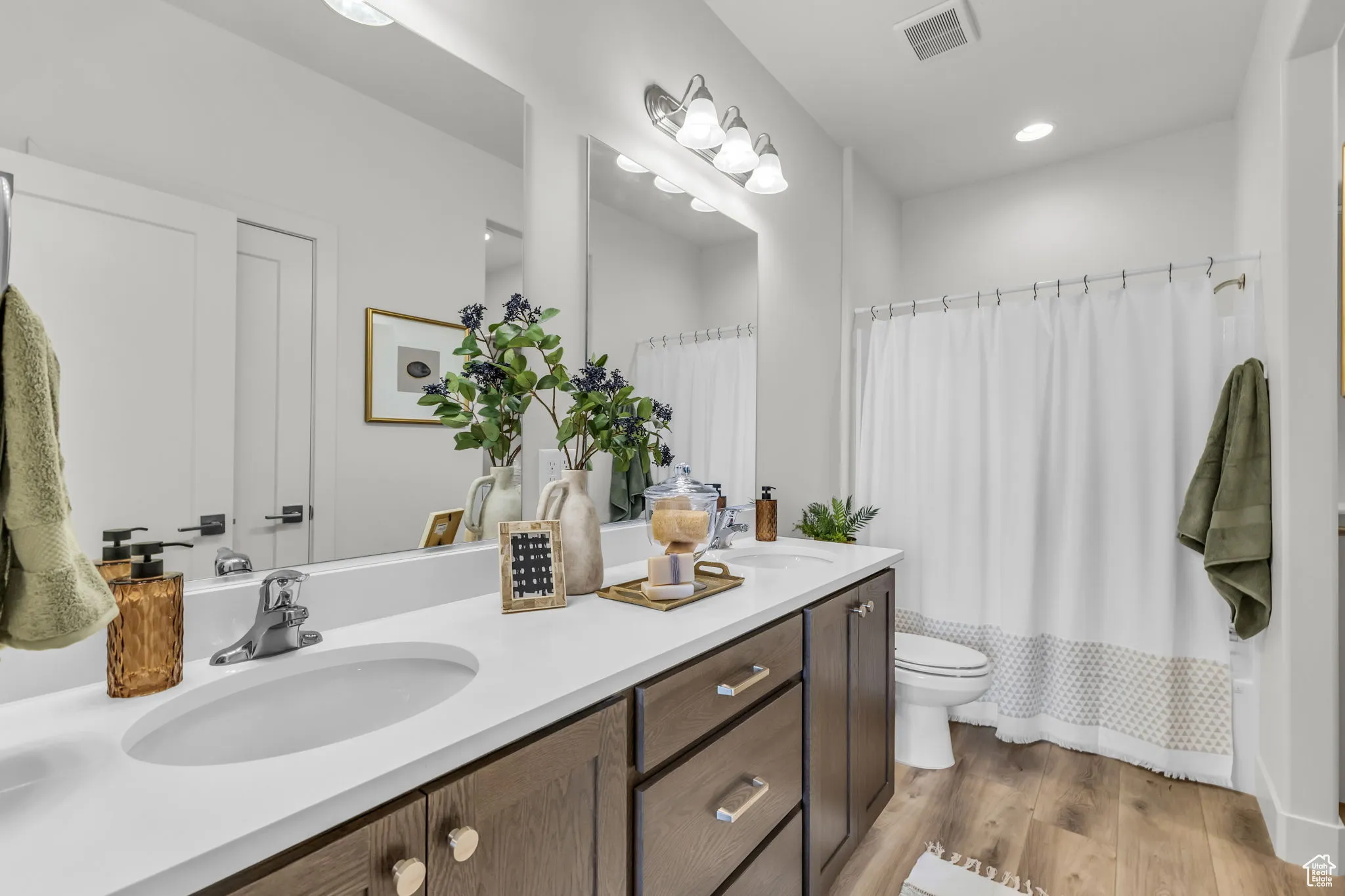 Full bathroom featuring hardwood / wood-style floors, vanity, toilet, and shower / bath combo