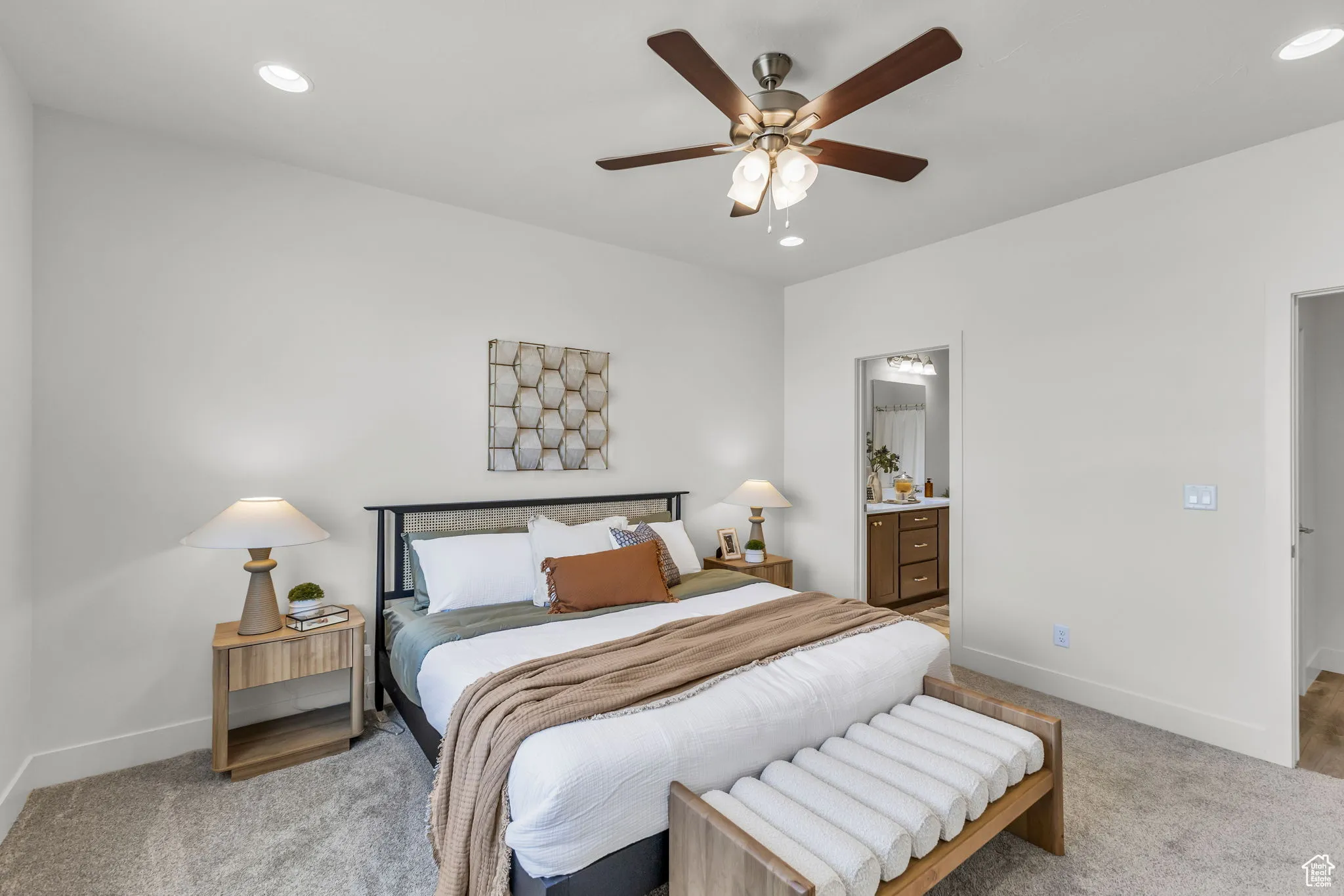 Bedroom featuring ceiling fan, light carpet, and connected bathroom