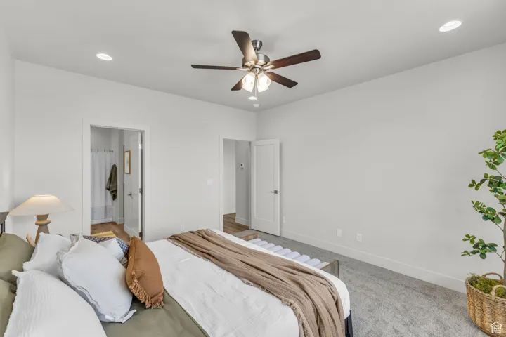 Bedroom with carpet, ensuite bath, and ceiling fan
