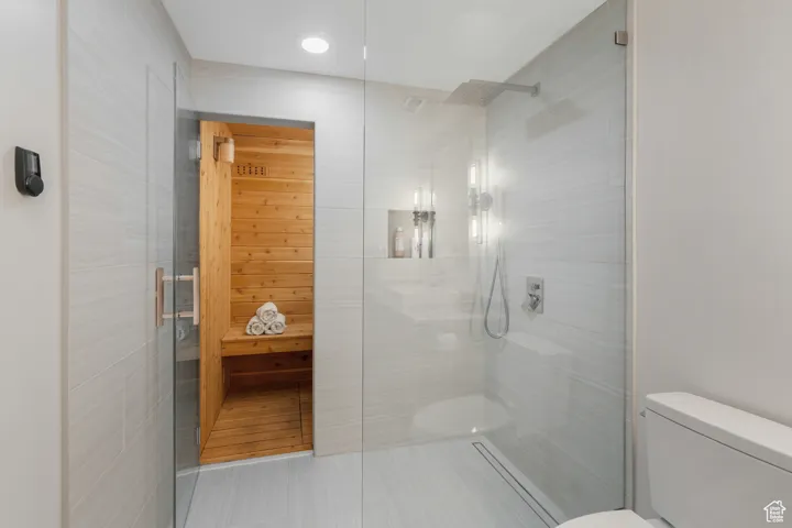 Bathroom featuring tile patterned flooring, toilet, and walk in shower