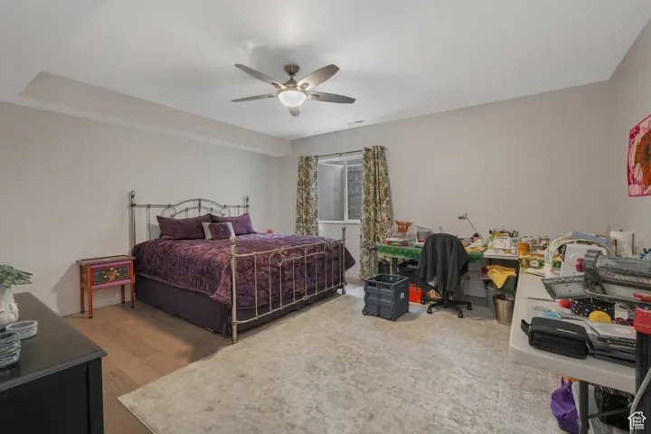 Bedroom with ceiling fan and wood-type flooring