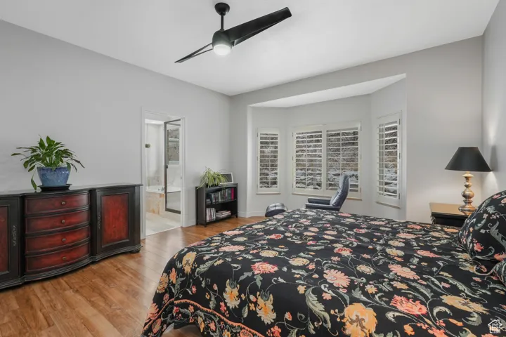 Bedroom with ceiling fan, ensuite bathroom, and light wood-type flooring
