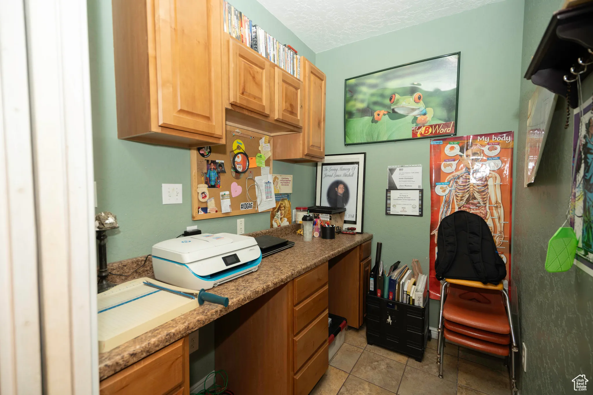 Kitchen featuring light tile patterned flooring, built in desk, and a textured ceiling
