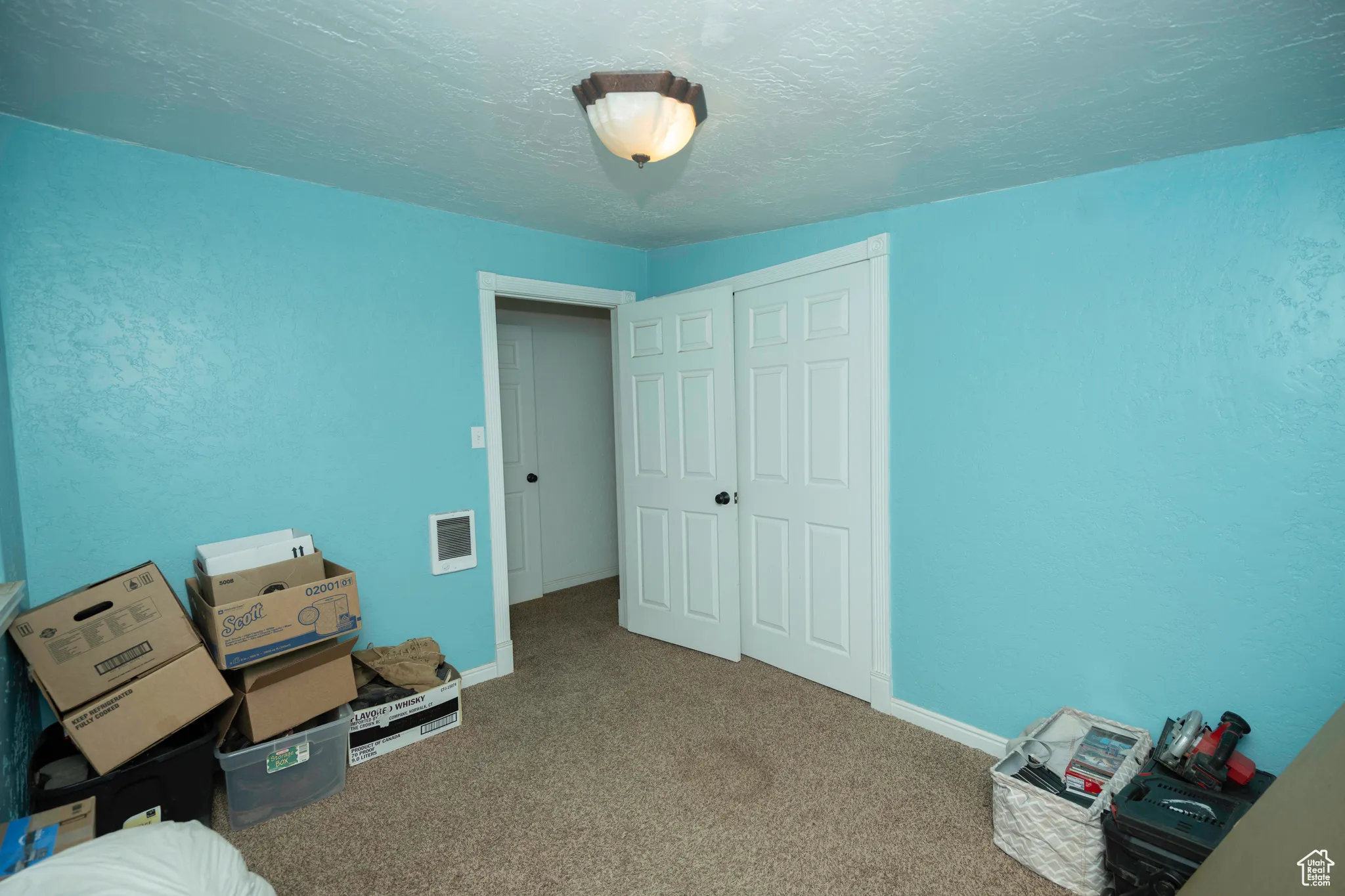 Unfurnished bedroom with a closet, a textured ceiling, and carpet