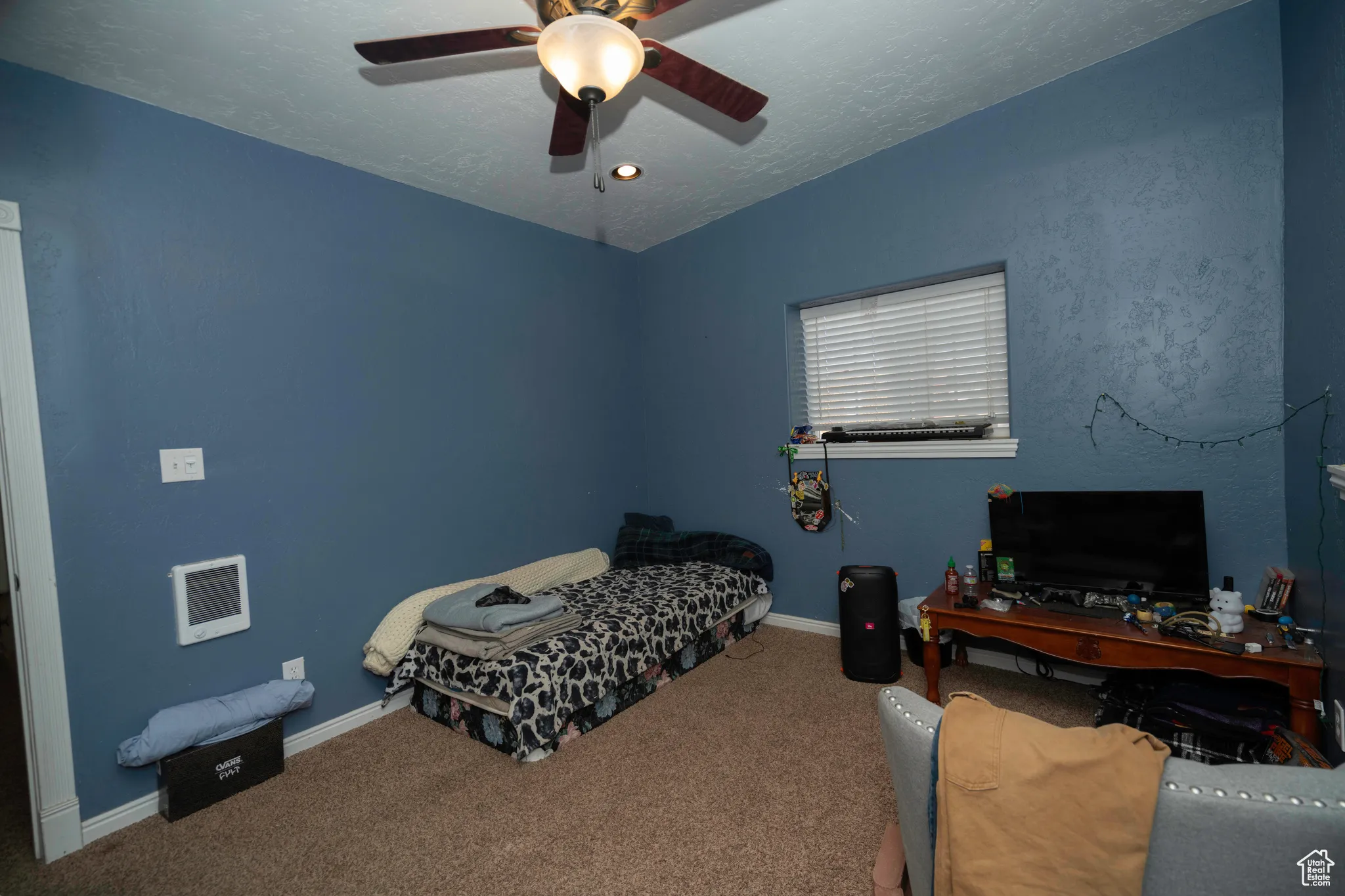 Bedroom featuring a textured ceiling, ceiling fan, and carpet flooring