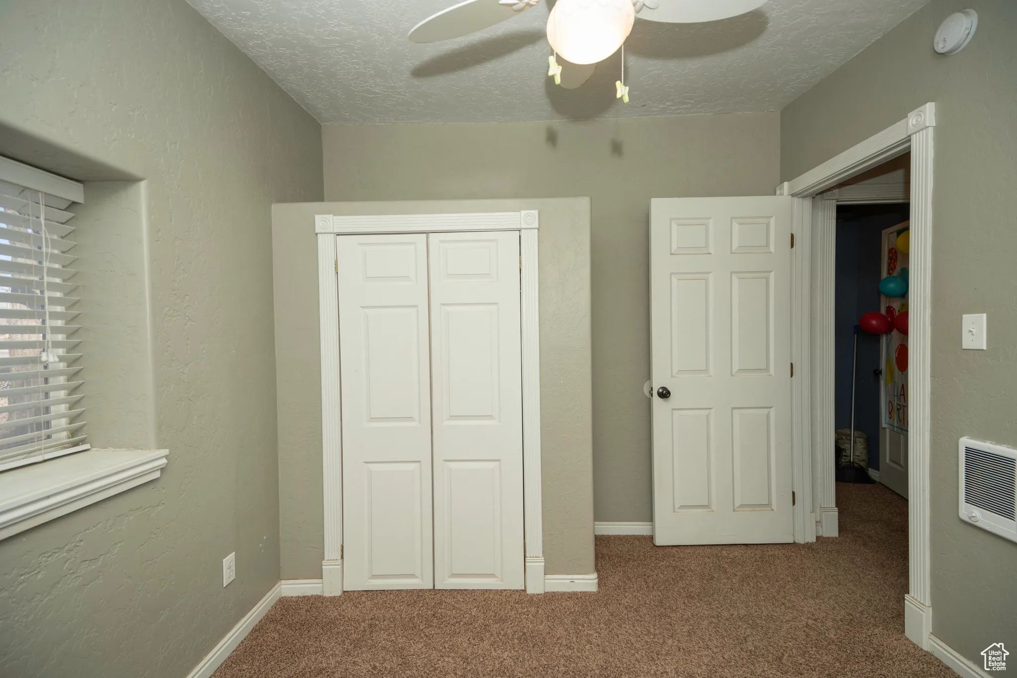 Unfurnished bedroom featuring ceiling fan, carpet flooring, a closet, and a textured ceiling
