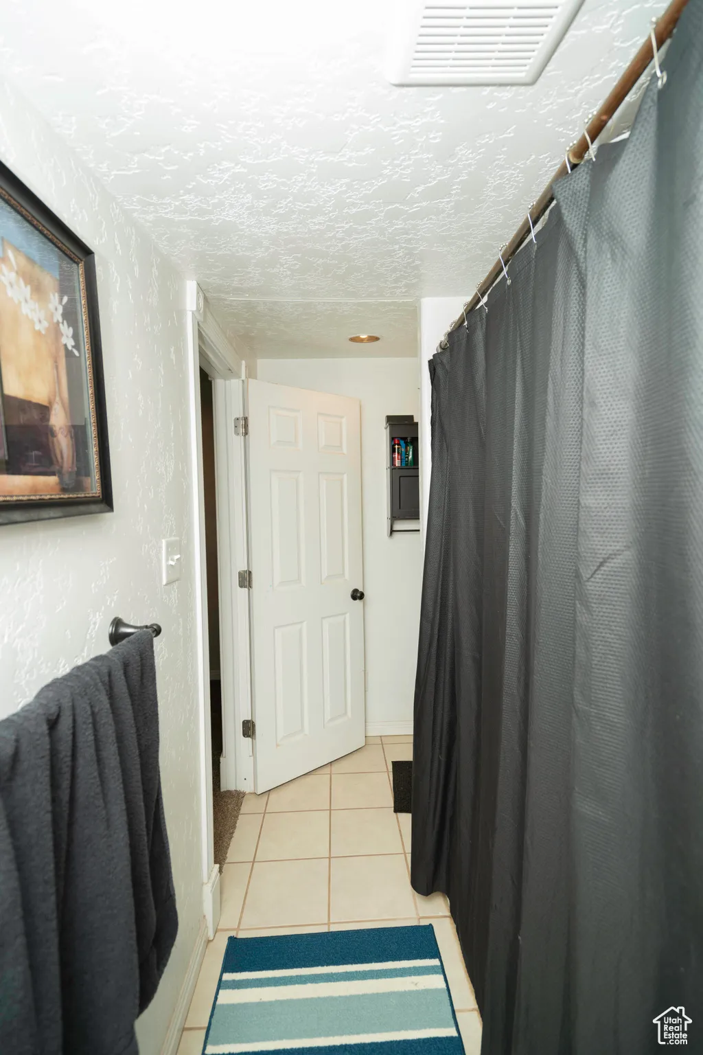 Bathroom featuring tile patterned flooring and a textured ceiling