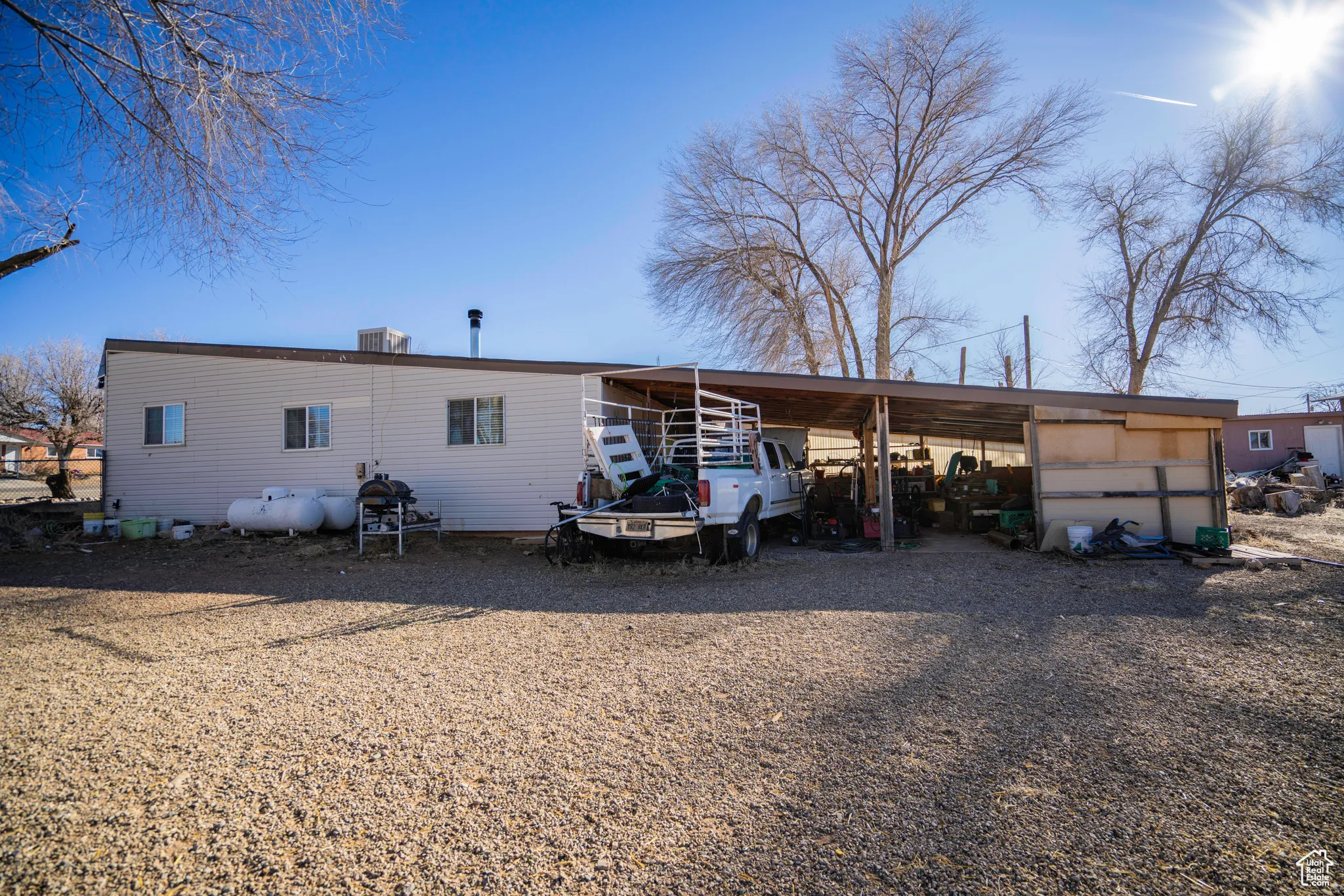 Back of property featuring cooling unit and a carport