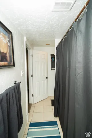 Bathroom featuring tile patterned flooring and a textured ceiling