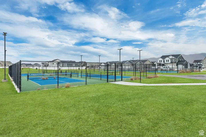 View of tennis court featuring a yard