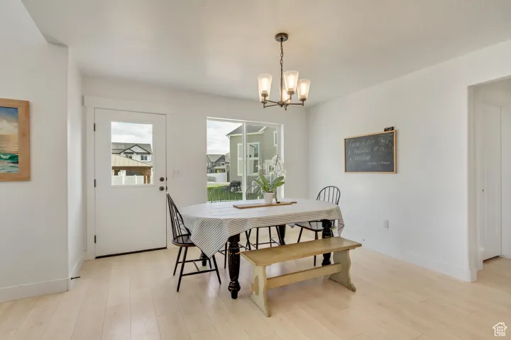 Dining area featuring an inviting chandelier and light wood-type flooring