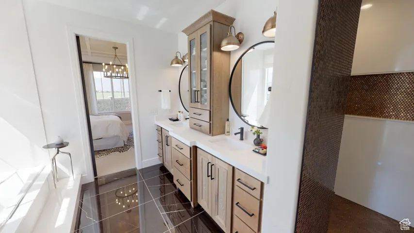 Bathroom featuring vanity, tile patterned floors, and a chandelier