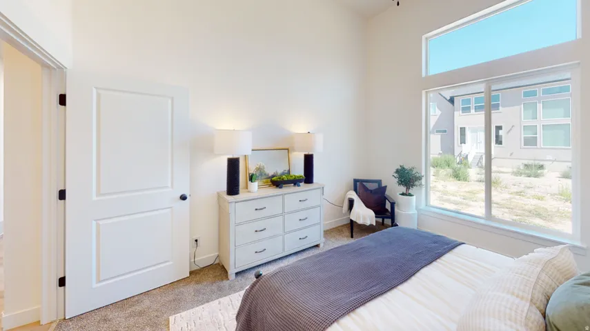 Bedroom featuring light carpet and baseboards
