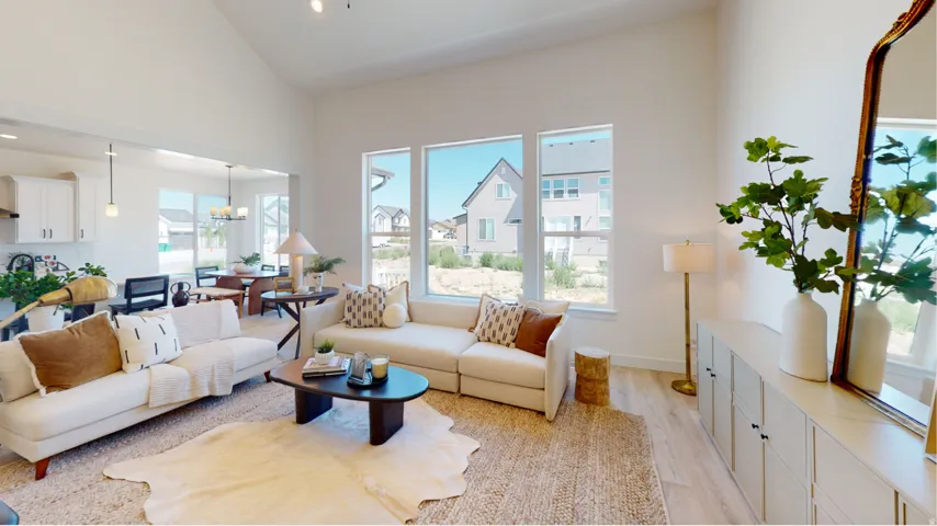 Living area with light wood finished floors, a chandelier, and high vaulted ceiling