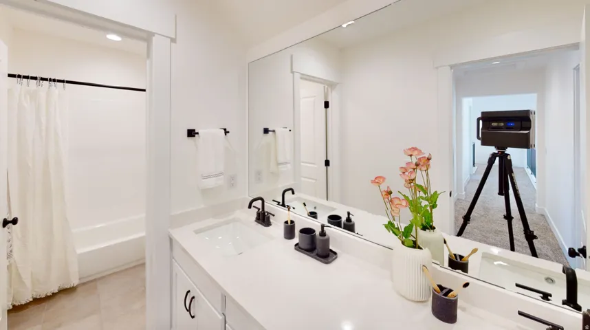 Bathroom featuring double vanity, shower / bathtub combination with curtain, and recessed lighting