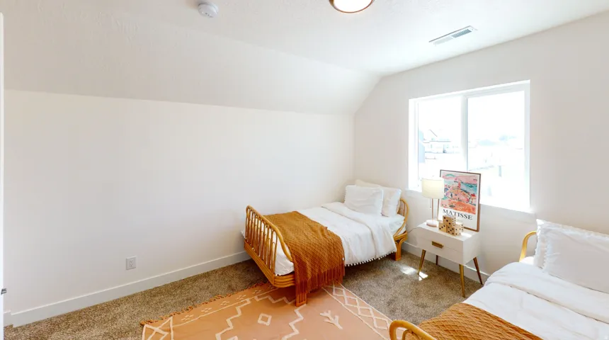 Bedroom featuring carpet, vaulted ceiling, and a textured ceiling