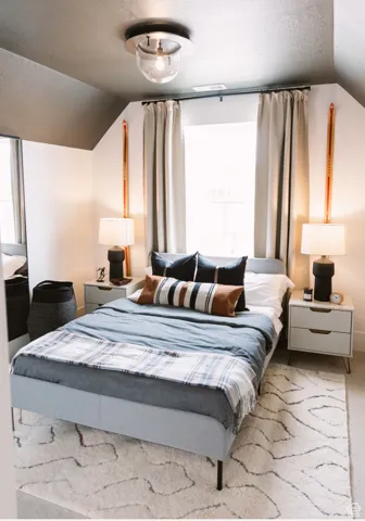 Carpeted bedroom featuring vaulted ceiling and a textured ceiling