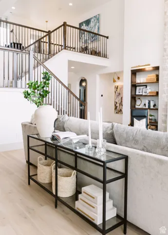 Living room featuring a towering ceiling and wood-type flooring