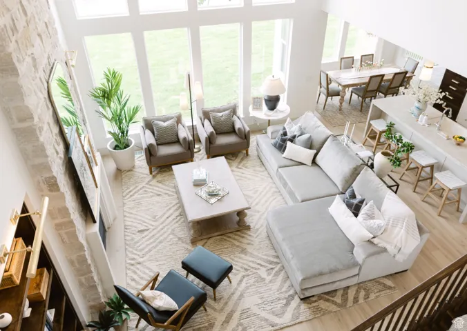 Living room with light hardwood / wood-style flooring and a high ceiling