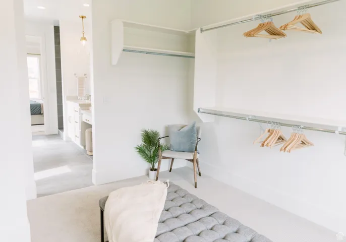 Walk in closet featuring light colored carpet