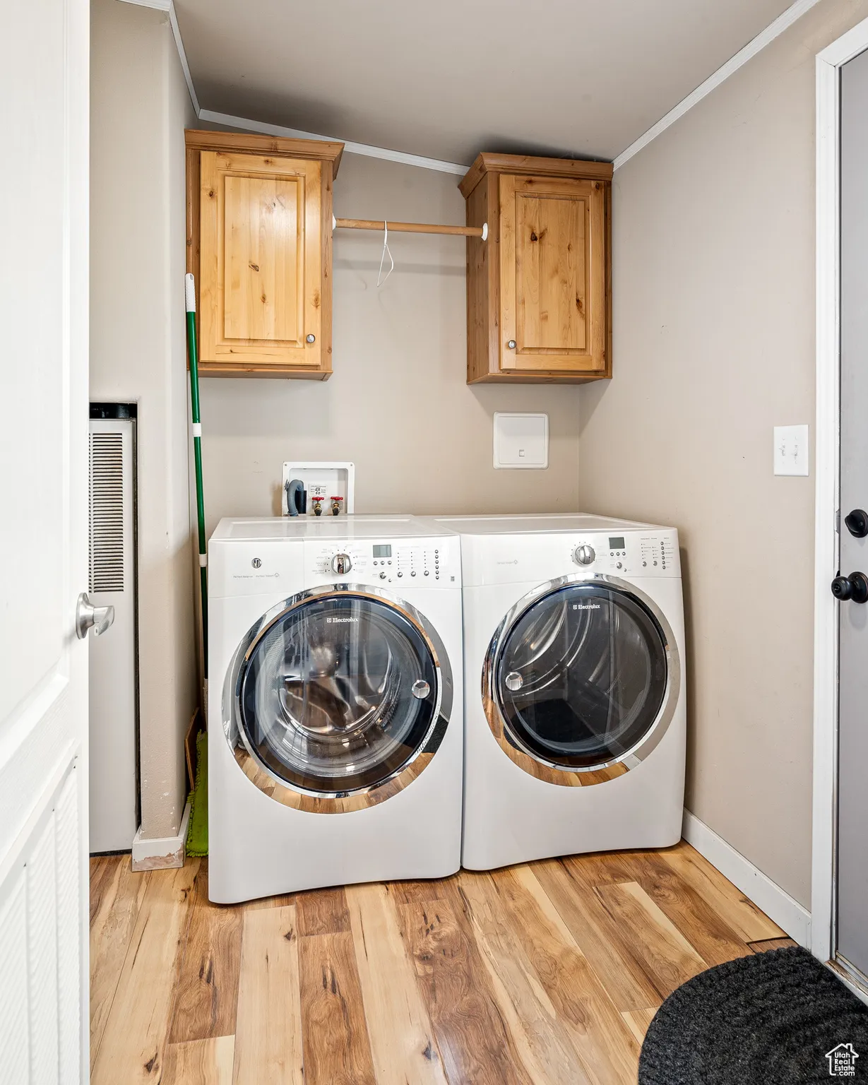 Laundry area with cabinets, crown molding, washer and dryer