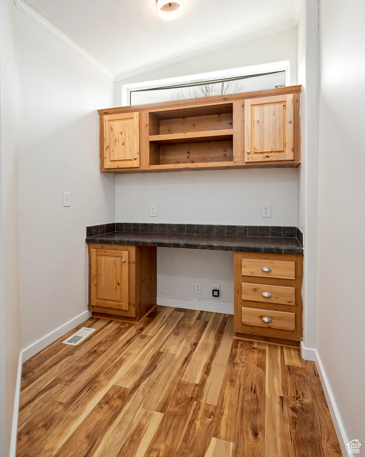 Unfurnished office with vaulted ceiling, crown molding and built in desk