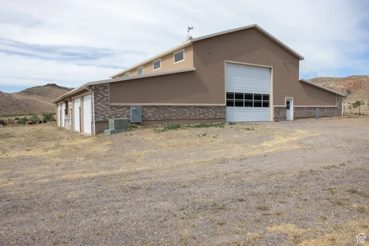 View of side of property featuring cooling unit, a mountain view, and a garage