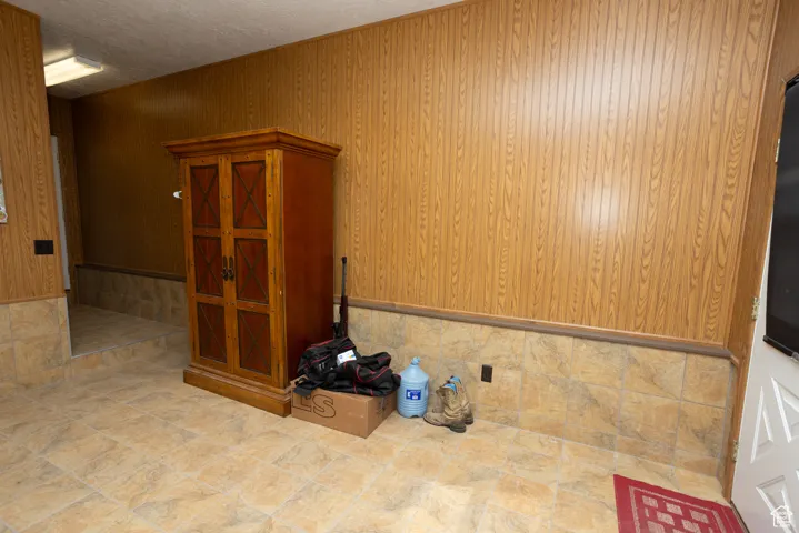 Spare room with wooden walls and a textured ceiling