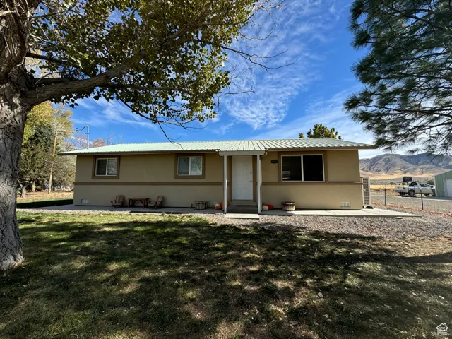 Single story home featuring a mountain view, a patio area, and a front lawn