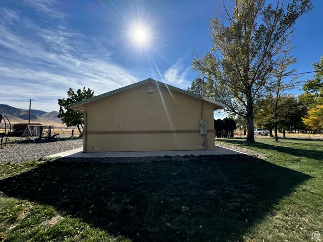 View of side of home featuring a playground, a mountain view, and a lawn