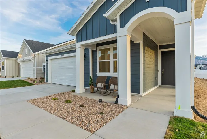 Entrance to property featuring a garage and covered porch